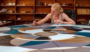 Kathleen Werner painting a large geometric canvas in her studio